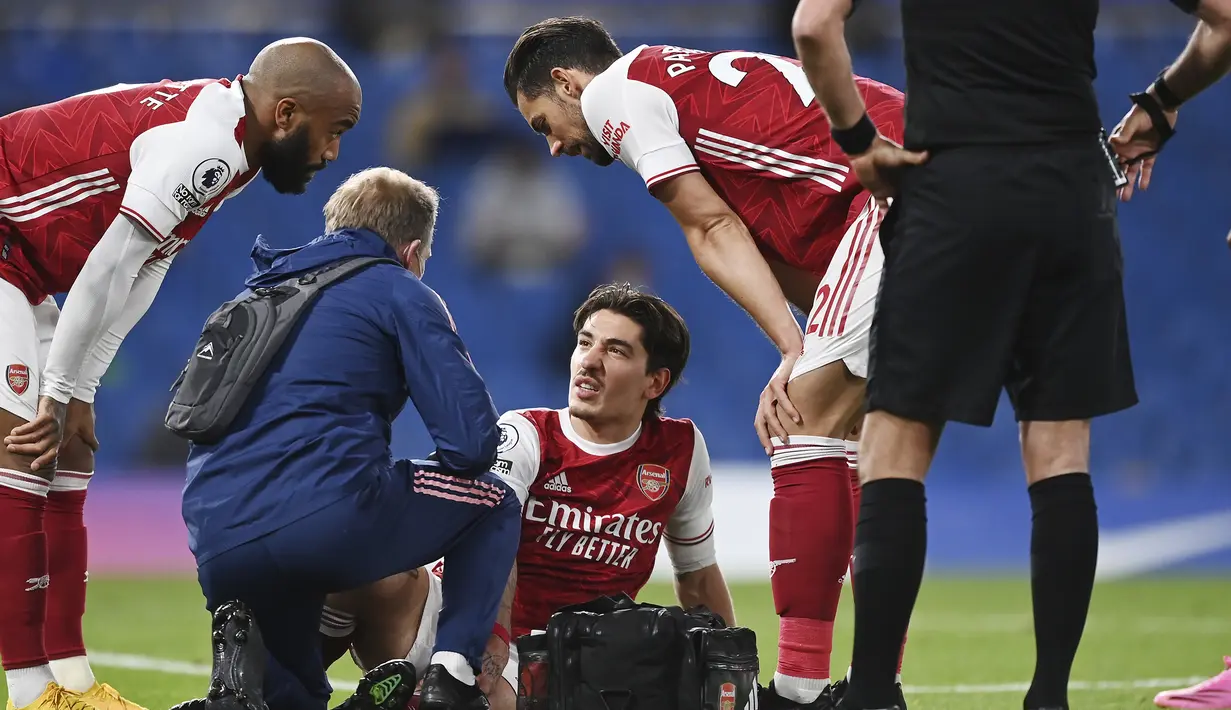 Bek Arsenal, Hector Bellerin (tengah) mendapat perawatan medis usai mengalami cedera saat melawan Chelsea dalam laga lanjutan Liga Inggris 2020/2021 pekan ke-35 di Stamford Bridge, London, Rabu (12/5/2021). Arsenal menang 1-0 atas Chelsea. (AP/Shaun Botterill/Pool)