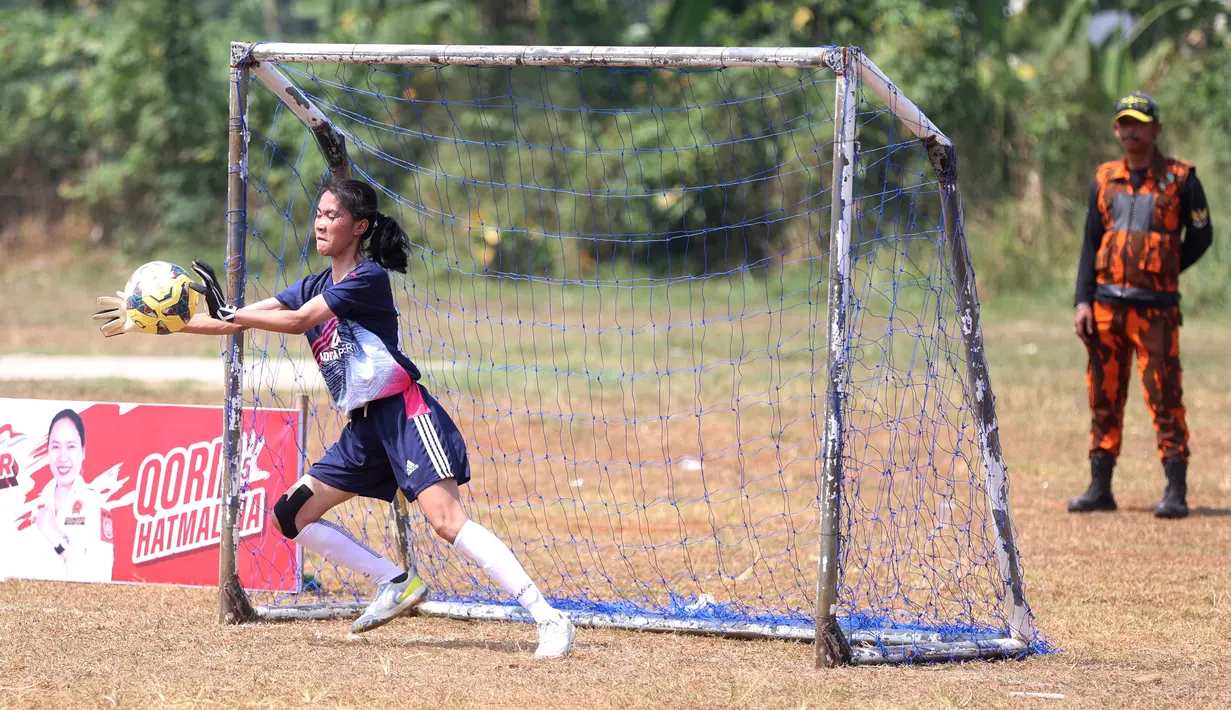 Kiper berusaha menangkap bola saat beraksi pada laga Bedahan Mini Soccer Cup II di Lapangan Bedahan, Depok, Minggu (6/8/2023). (Bola.com/M Iqbal Ichsan)