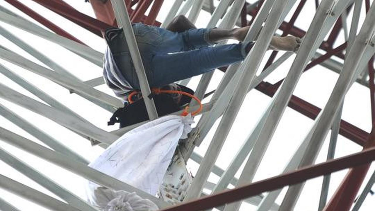 Pria berpakaian pocong di atas tower SUTET