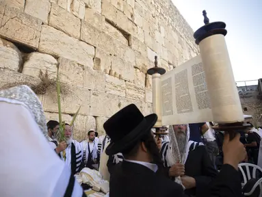 Pria Yahudi Ultra-Ortodoks berdoa selama hari raya Yahudi Sukkot di Tembok Barat, situs paling suci di mana orang Yahudi dapat berdoa di Kota Tua Yerusalem, Rabu (22/9/2021).  (AP Photo/Sebastian Scheiner)