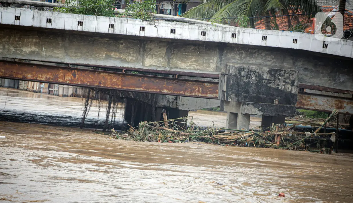 Tumpukan sampah tersangkut pada jembatan saat banjir akibat luapan Sungai Ciliwung, Jakarta, Senin (10/10/2022). Hingga pukul 09.00 WIB hari ini, Badan Penanggulangan Bencana Daerah (BPBD) DKI Jakarta mencatat sebanyak 68 RT di Jakarta terendam banjir akibat luapan Sungai Ciliwung. (Liputan6.com/Faizal Fanani)