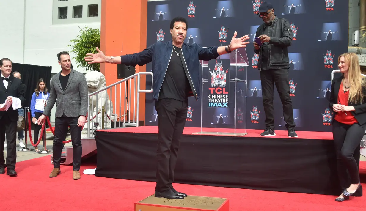 Penyanyi R&B AS, Lionel Richie berpose sambil membubuhkan cap kakinya di TCL Chinese Theatre, Hollywood, Rabu (7/3). Richie menerima berbagai penghargaan internasional dan penghargaan dari sejumlah negara. (Tommaso Boddi/Getty Images/AFP)
