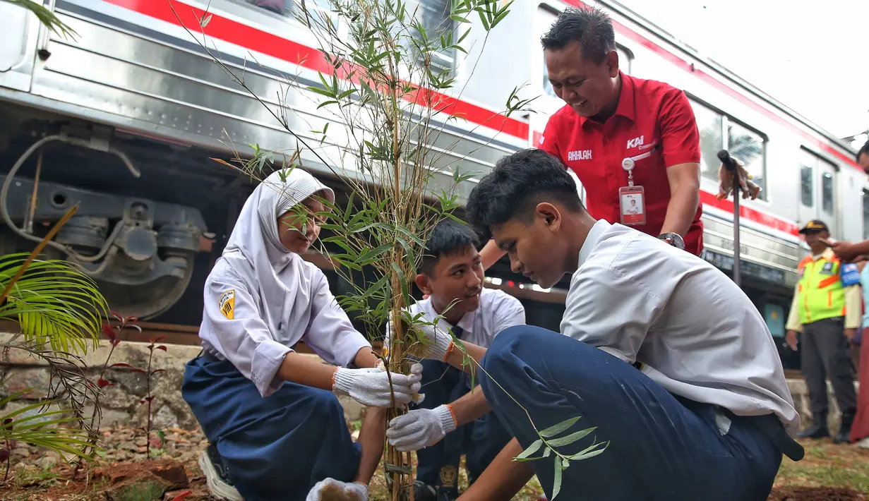 Direktur Operasi dan Pemasaran PT Kereta Commuter Indonesia (KCI), Broer Rizal bersama pelajar membuat lubang resapan biopori dan menanam pohon bambu di Stasiun Rawa Buaya, Jakarta Barat, Kamis (12/9/24). (Liputan6.com/Angga Yuniar)