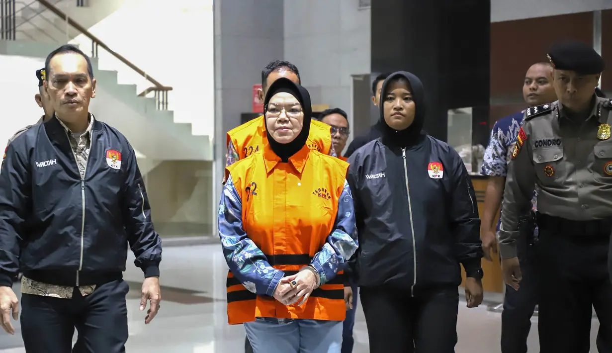 Bupati Sukoharjo Etik Suryani mengenakan rompi tahanan  dibawa menuju mobil tahanan usai menjalani pemeriksaan di Gedung Merah Putih KPK, Jakarta, Sabtu (11/7/2026). (KLY/Arie Basuki)