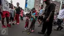 Seorang anak perempuan melilitkan seekor ular di badannya saat momen Car Free Day (CFD) di kawasan Bundaran HI, Jakarta, Minggu (29/1). Tak sedikit pengunjung Car Free Day yang ingin berfoto dengan hewan reptil tersebut. (Liputan6.com/Faizal Fanani)