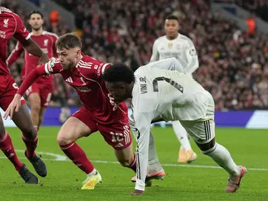 Pemain Liverpool, Conor Bradley (kiri) berebut bola dengan pemain Real Madrid, Vinicius Jr dalam laga Liga Champions 2025/2026 di Anfield, Liverpool, Inggris, Selasa (04/11/2025) waktu setempat. (AP Photo/Jon Super)