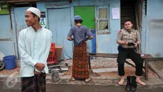 Warga bersama anggota polisi seusai melaksanakan Shalat Jumat di sebuah masjid di kawasan Kalijodo, Jakarta, Jumat (26/2). Shalat Jumat ini merupakan yang terakhir sebelum penertiban kawasan Kalijodo oleh Pemkot DKI. (Liputan6.com/Gempur M Surya)