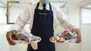 Pekerja memegang sepatu kets unik kolaborasi Adidas dan produsen porselen Meisse bernama Porcelain ZX8000, saat pratinjau di rumah lelang Sotheby di New York City pada 4 Desember 2020. Sepatu yang akan dilelang bulan ini diperkirakan terjual dengan nilai hingga 1 juta dollar AS. (Kena Betancur/AFP)