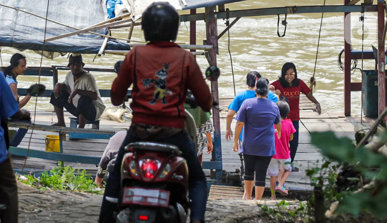Warga bersiap menaiki perahu eretan di Sungai Cisadane, Neglasari, Kota Tangerang, Kamis (7/10/2021). Keberadaan jasa penyeberangan perahu eretan dengan tarif Rp 2.000 tersebut guna mempersingkat jarak tempuh dan waktu. (Liputan6.com/Angga Yuniar)