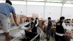 Petugas menurunkan bantuan 4 tenda darurat dan kebutuhan lainnya dari PT Jakarta International Container Terminal (JICT) untuk korban gempa dan tsunami di Palu dan Donggala di Gudang IHC-ACT Parung, Bogor, Jumat (12/10). (Liputan6.com/HO/Arif)