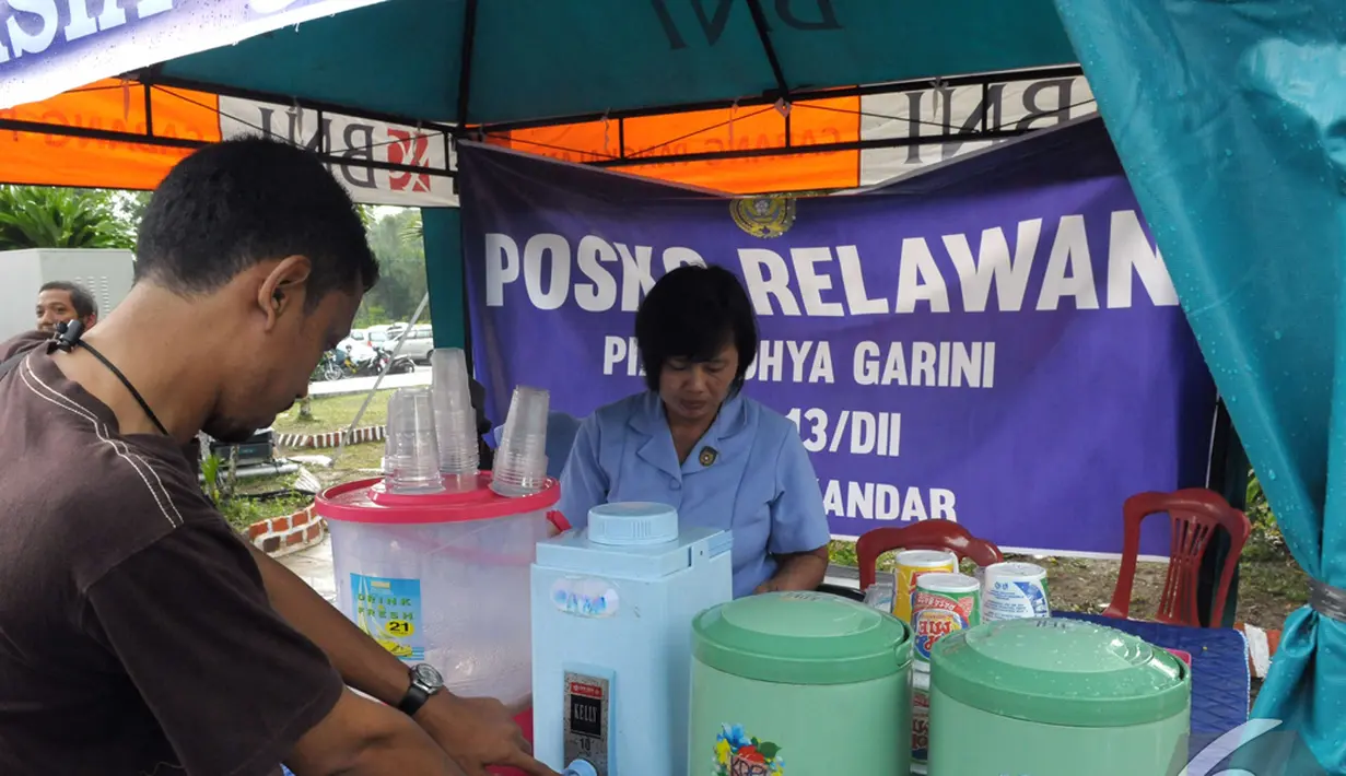 Seorang wartawan mengambil kopi yang disuguhkan oleh Posko Relawan, Pangkalan Bun Kalimantan Tengah, Kamis (8/1/2015). (Liputan6.com/Andrian M Tunay)