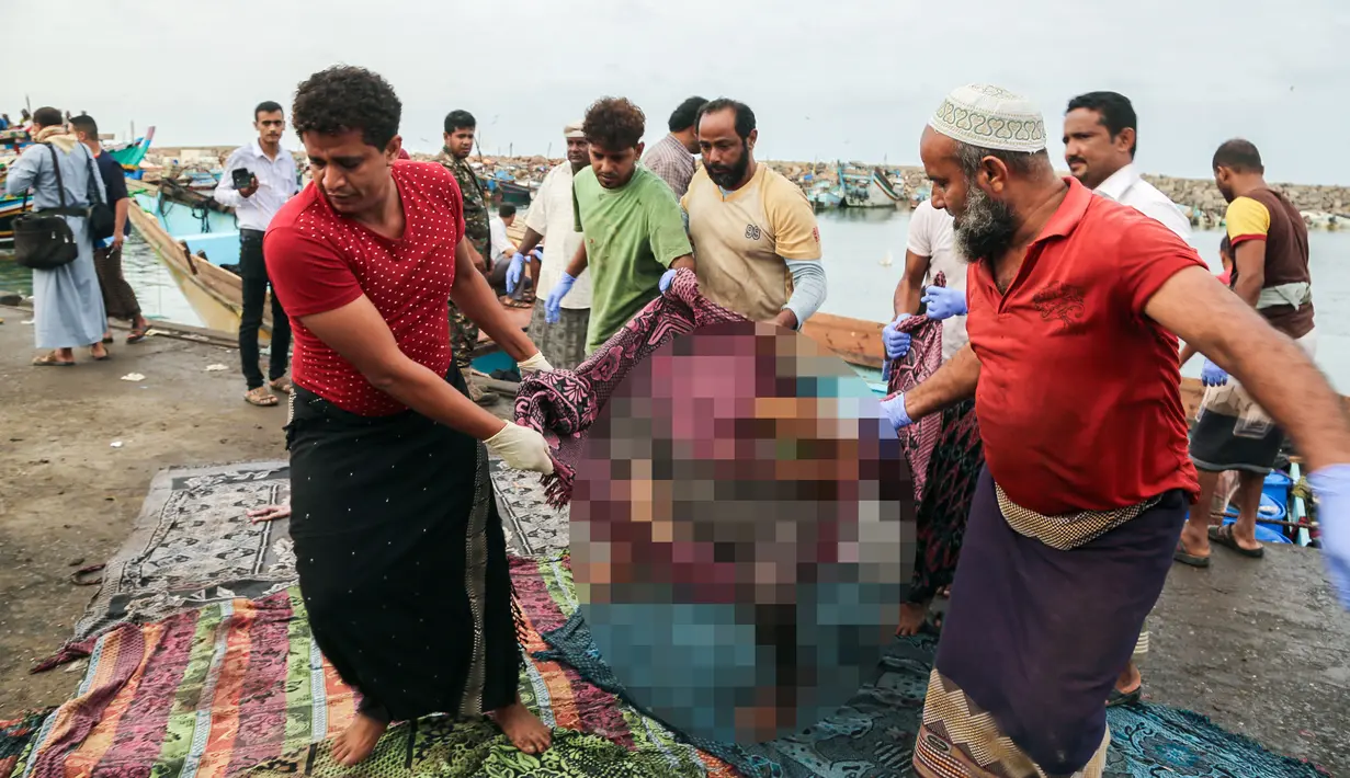 Warga mengevakuasi jenazah pengungsi Somalia yang tewas akibat serangan sebuah helikopter di lepas pantai Yaman, Jumat (17/3). (AFP Photo/STR)