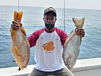 Pemancing menunjukkan ikan hasil tangkapannya pada kegiatan BNI Fun Fishing 2021 di perairan Selat Sunda, Banten, Sabtu (16/10/2021). Para pemancing berlomba-lomba mencari ikan terbesar dan terbanyak yang bisa dibawa pulang. (Liputan6.com/HO/Fun Fishing)