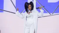 Rapper Cardi B menjadi salah satu penampil dalam festival musik tahunan Coachella 2018 di Indio, California, Minggu (15/4). Mengenakan tube top, celana panjang, serta sneakers putih, Cardi B tampil superenergik. (Amy Harris/Invision/AP)