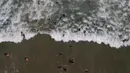 Orang-orang berenang di lepas pantai Los Angeles setelah baru-baru ini dibuka kembali di La Guaira, Venezuela, Jumat (23/10/2020). Pemberlakuan lockdown yang ketat akibat COVID-19 memaksa penutupan pantai di seluruh negeri pada Maret lalu dan dibuka kembali minggu ini. (AP/Matias Delacroix)