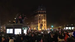 Suporter Prancis bergembira di alun-alun Bastille usai kemenangan pertandingan semifinal Piala Dunia 2022 melawan Maroko, di Paris, Kamis (15/12/2022). Prancis berhasil mengalahkan Maroko dengan skor 2-0 dan melaju ke babak final menghadapi Argentina. (AP Photo/Aurelien Morissard)