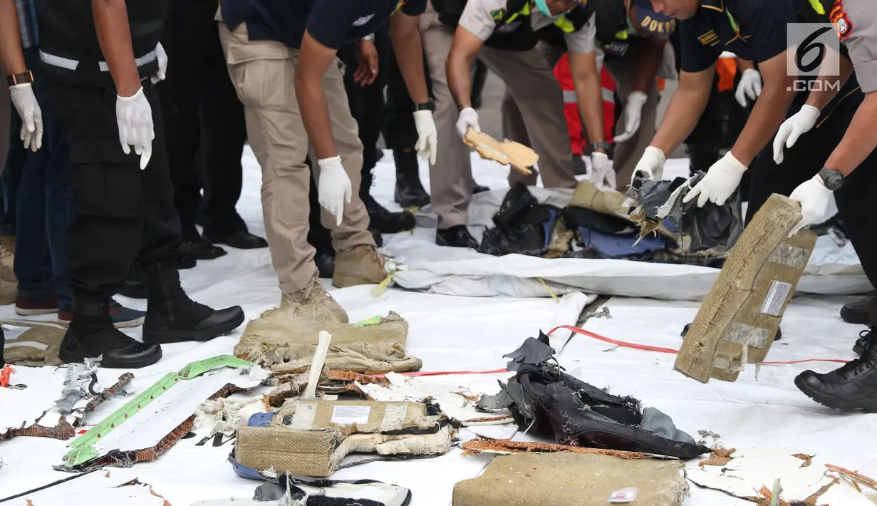 Petugas merapikan sejumlah barang temuan yang diduga serpihan pesawat Lion Air JT 610 di Pelabuhan JICT 2, Jakarta, Selasa (30/10). Sejumlah barang ditemukan petugas gabungan dalam operasi pencarian. (Liputan6.com/Helmi Fithriansyah)