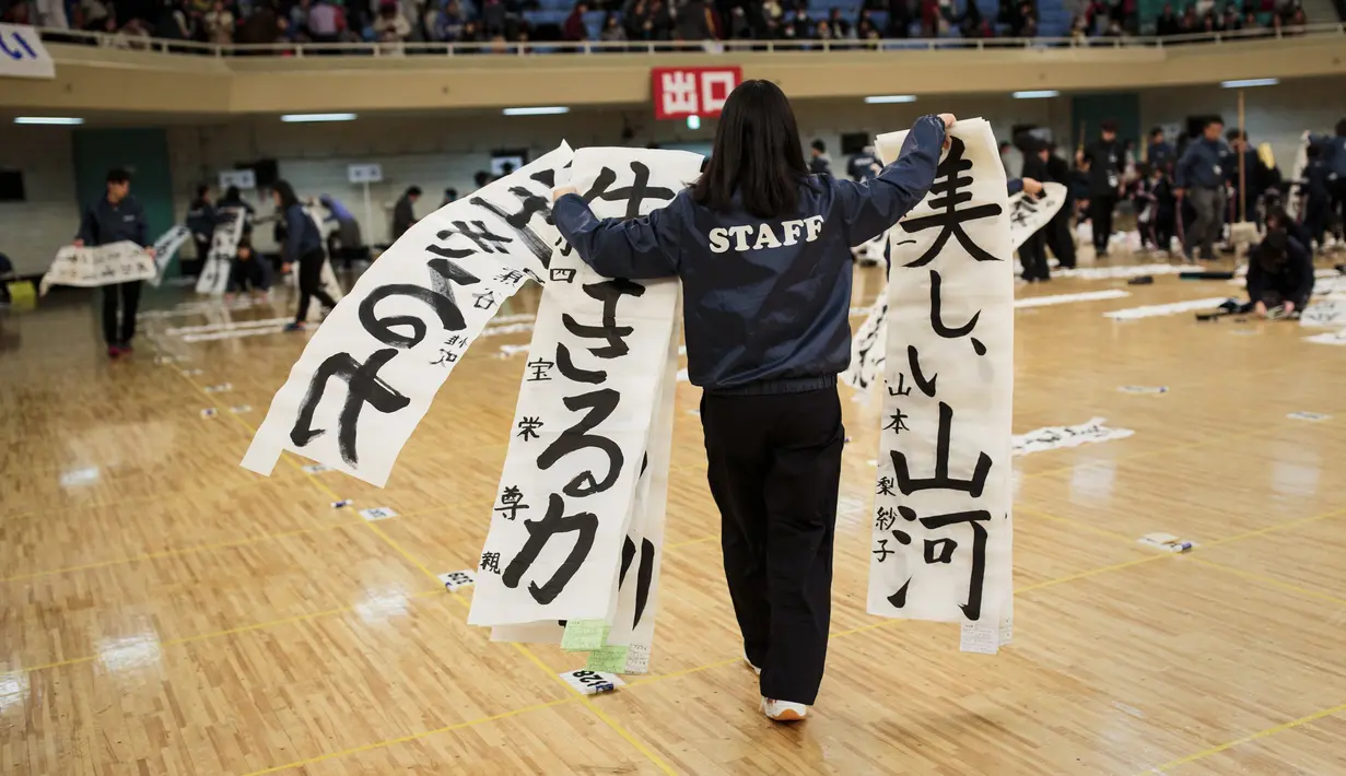 Panitia mengumpulkan kertas yang telah ditulisi untuk dinilai saat lomba kaligrafi Tokyo, Jepang (5/1). Lomba kaligrafi tulisan Jepang ini digelar setiap tahun yang diadakan pada awal tahun baru. (AFP Photo/Behrouz Mehri)