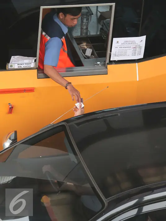 Petugas menerima pembayaran tarif tol, Jakarta, Minggu (1/11/2015). Sebanyak 15 ruas tol mengalami kenaikan tarif per 1 November. (Liputan6.com/Angga Yuniar)