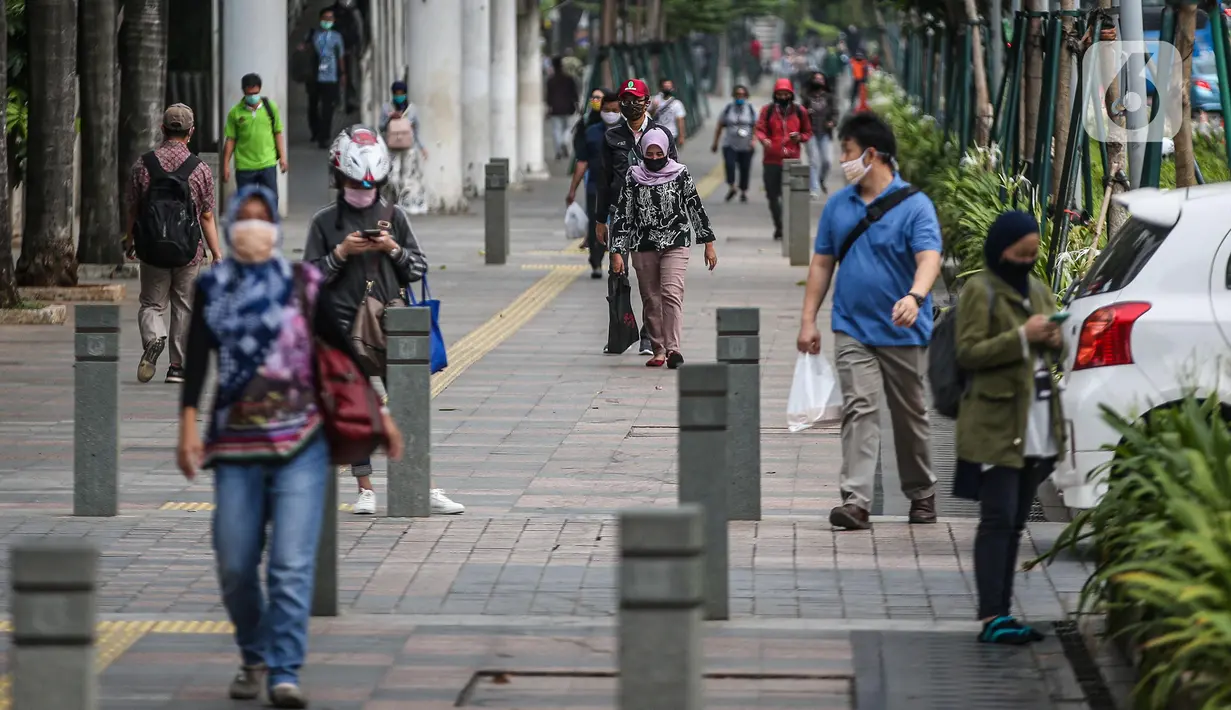 Suasana jam pulang kerja di jalur pedestrian kawasan Sudirman, Jakarta, Senin (22/6/2020). Pemprov DKI Jakarta menerapkan perubahan sif kerja untuk mengurangi kepadatan lalu lintas dan transportasi umum pada masa PSBB transisi. (Liputan6.com/Faizal Fanani).