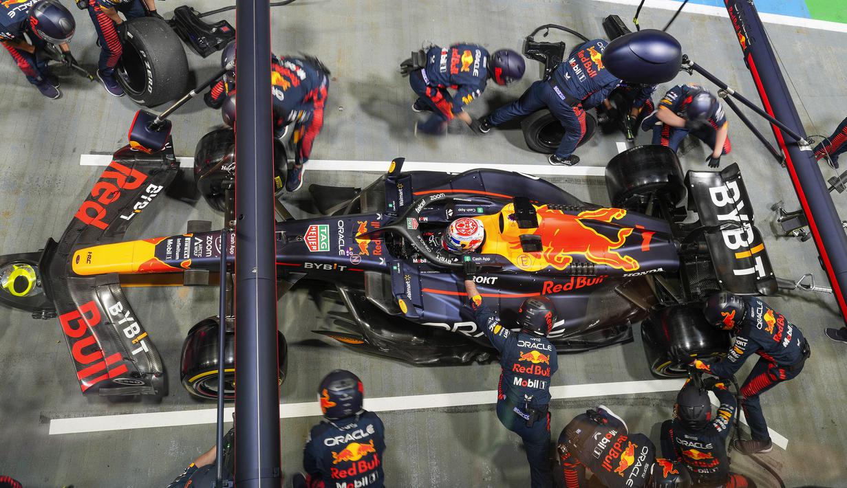 Pembalap tim Red Bull, Max Verstappen berada di pit area saat mobilnya tengah ditangani para mekanik untuk mengganti ban pada balapan F1 GP Singapura 2023 di Marina Bay Street Circuit, Singapura, Minggu (17/9/2023) malam WIB. (AFP/Vincent Thian)