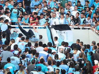 Seorang fans dari tim Belgrano, Emanuel Balbo, didorong oleh pendukung lainnya hingga jatuh dari tribun Stadion Belgrano, Kota Cordoba di Argentina, 15 April 2017. Insiden terjadi ketika Belgrano berhadapan dengan tim tamu, Talleres (NICOLAS AGUILERA/AFP)