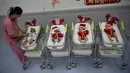 Perawat merapikan pakaian bayi yang baru lahir di Rumah Sakit Synphaet, Bangkok, Thailand, Selasa (24/12/2019). Bayi-bayi tersebut dipakaikan kostum sinterklas untuk menyambut Hari Raya Natal. (AP Photo/Sakchai Lalit)