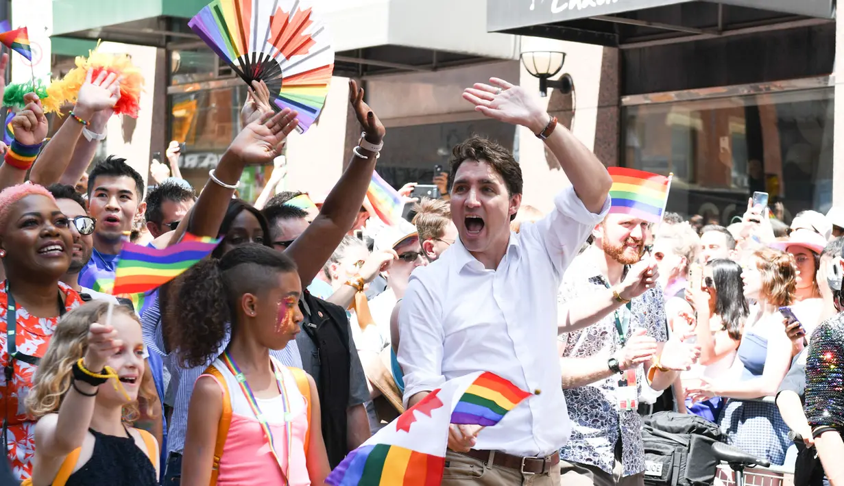 Perdana Menteri Kanada Justin Trudeau menyapa warga saat mengikuti pawai LGBT Toronto's Pride Parade di Toronto, Kanada, Minggu (23/6/2019). Pawai digelar untuk mengenang peristiwa Stonewall yang terjadi di New York pada Juni 1969. (George Pimentel/GETTY IMAGES NORTH AMERICA/AFP)