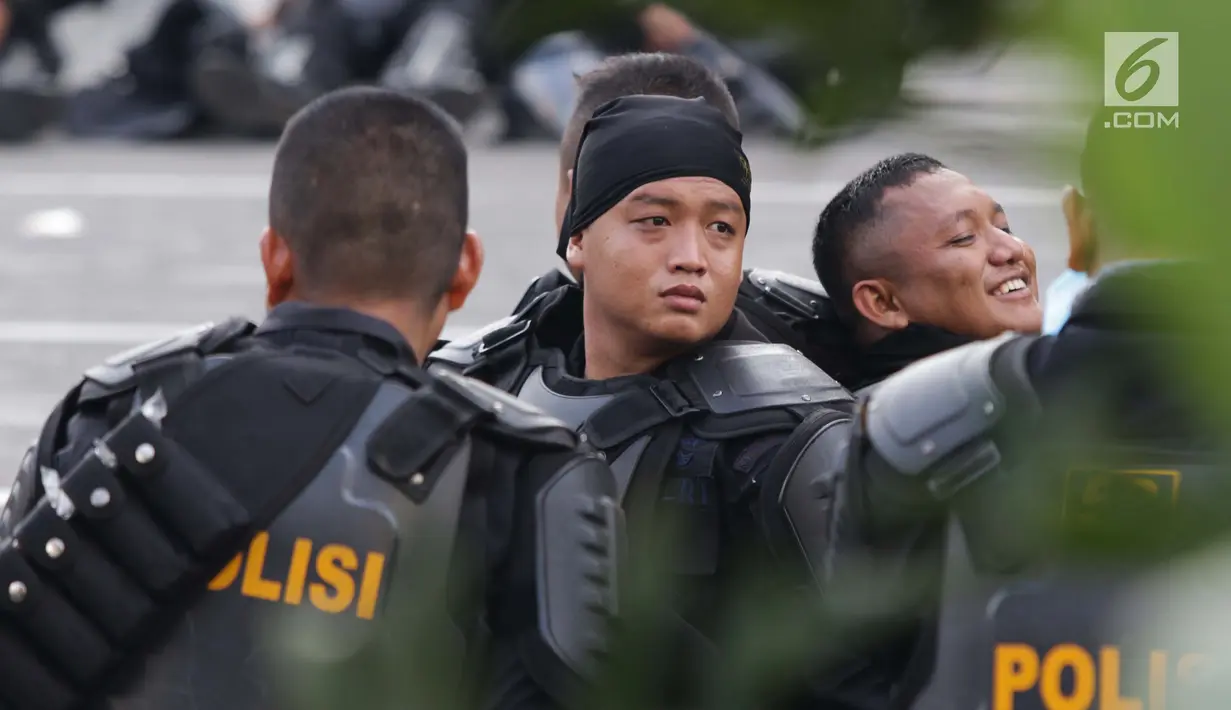 Personil kepolisian dari satuan Brimob beristirahat saat menjaga aksi unjuk rasa yang dilakukan Gerakan Nasional Kedaulatan Rakyat di depan Gedung Bawaslu, Jakarta, Selasa (21/5/2019). Ribuan aparat keamanan gabungan diterjunkan untuk mengamankan jalannya aksi. (Liputan6.com/Helmi Fithriansyah)
