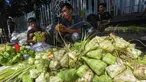 Pedagang melayani pembuatan kulit ketupat di Pasar Pondok Labu, Jakarta Selatan, Minggu (30/3/2025). (merdeka.com/Arie Basuki)