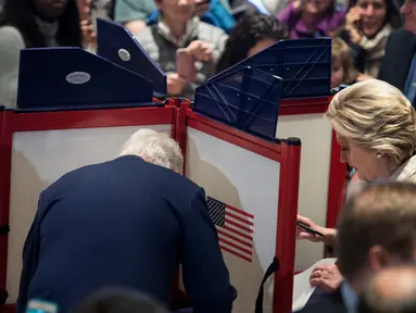 Calon Presiden AS dari Partai Demokrat, Hillary Clinton (kanan) dan suaminya Bill Clinton memberikan suaranya saat pemilihan presiden AS di Chappaqua, New York, AS, Selasa (8/11). (AFP PHOTO / Brendan Smialowski)