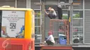 Pekerja merenovasi halte Busway Harmoni, Jakarta, Jum'at (29/1/2016). Perbaikan dilakukan pada jalur masuk penumpang karena sempat ambruk beberapa waktu lalu. (Liputan6.com/Faisal R Syam)