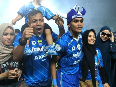 Pemain Persib Bandung, Rachmat Irianto (tengah kanan) bersama ayahnya, Bejo Sugiantoro (tengah kiri) dan keluarganya merayakan kemenangan atas Madura United pada laga leg 1 final Championship Series BRI Liga 1 2023/2024 di Stadion Si Jalak Harupat, Bandung, Minggu (26/05/2024). (Bola.com/M Iqbal Ichsan)