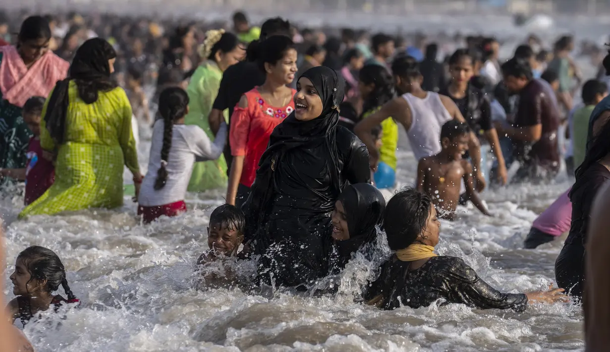 <p>Pengunjung memadati pantai Juhu di Laut Arab pada hari yang panas dan lembab di kota Mumbai, India, 8 Mei 2022. Tingginya suhu udara diperparah dengan kurangnya curah hujan. Maret lalu tercatat sebagai bulan terpanas di India sejak 122 tahun lalu. (AP Photo/Rafiq Maqbool)</p>