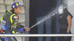 Pembalap Monster Yamaha, Valentino Rossi, merayakan kemenangan di atas podium usai menjuarai MotoGP Andalusia di Sirkuit Jerez, Minggu (26/7/2020). Fabio Quartararo berhasil finis pertama dengan catatan waktu 41 menit 22,666 detik. (AP Photo/David Clares)