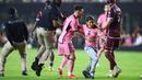 Seorang gadis berusaha melarikan diri setelah memasuki lapangan untuk berswafoto dengan Lionel Messi pada laga lanjutan Major League Soccer (MLS) antara Inter Miami melawan Colorado Rapids di Fort Lauderdale, Florida, Amerika Serikat, Minggu (07/04/2024) WIB. (AFP/Megan Briggs)