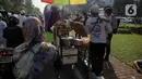 Pedagang ketupat sayur melayani pembeli saat berjualan di tengah aksi reuni 212, sekitaran Jalan Medan Merdeka Barat, Jakarta, Senin (2/12/2019). Sejumlah PKL meraup untung dengan berjualan di tengah ribuan massa Persaudaraan Alumni 212 yang mengikuti reuni di Monas. (Liputan6.com/Faizal Fanani)