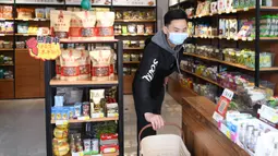 Seorang pria bekerja di toko makanan ringan miliknya di Distrik Xiling, Kota Yichang, Provinsi Hubei, China, Jumat (20/3/2020). Berbagai retail dan pusat perbelanjaan secara bertahap melanjutkan aktivitasnya setelah meredanya kasus virus corona COVID-19 di China. (Xinhua/Cheng Min)