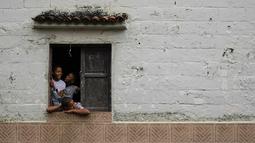 Anak-anak menyaksikan perayaan Hari Orang Suci yang Tak Bersalah di Caucagua, Venezuela, Selasa (28/12/2021). Tradisi berusia lebih dari 200 tahun adalah hari nyanyian, tarian, dan lelucon. (AP Photo/Matias Delacroix)