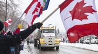 Orang-orang berkumpul untuk memprotes mandat COVID-19 dan mendukung protes terhadap pembatasan COVID-19 yang berlangsung di Ottawa, di Edmonton, Alberta, Sabtu, 5 Februari 2022. (Jason Franson/The Canadian Press via AP)