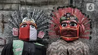Ondel-ondel yang mengenakan masker dipajang di Kramat Pulo, Jakarta, Rabu (10/2/2021). Pendapatan sejumlah sanggar ondel-ondel di Kramat Pulo merosot karena larangan menggelar pesta pernikahan atau sejenisnya selama pandemi. (merdeka.com/Iqbal S. Nugroho)
