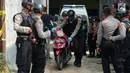 Polisi membawa sepeda motor saat menggelar olah tempat kejadian perkara (TKP) di rumah terduga teroris di Nanggewer, Cibinong, Bogor, Jawa Barat, Sabtu (18/5/2019). Terduga teroris E alias AR alias Pak Jenggot ditangkap di rumahnya pada Jumat 17 Mei 2019. (merdeka.com/Imam Buhori)