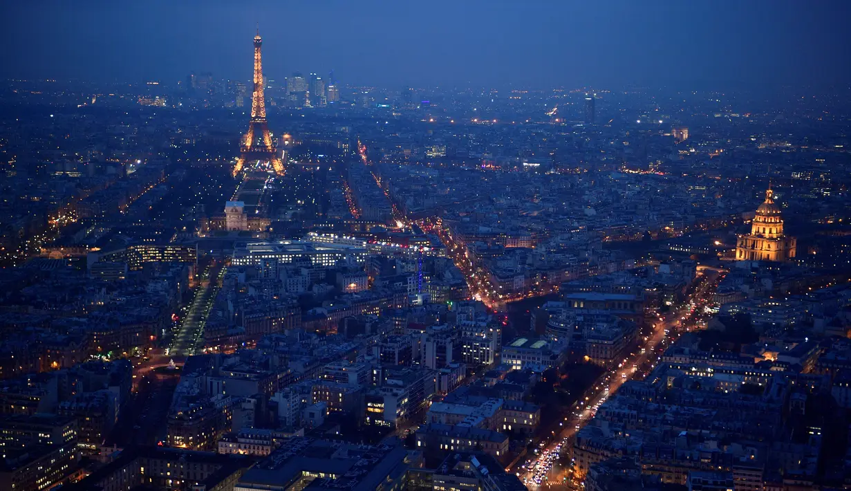 Pemandangan kota Paris saat sore hari dari atap gedung pencakar langit "The Tour Montparnasse", memperlihatkan Menara Eiffel dan kubah Hotel Les Invalides, Senin (8/1). Gedung satu ini memikat wisatawan yang melancong ke kota Paris. (CHRISTOPHE SIMON/AFP)