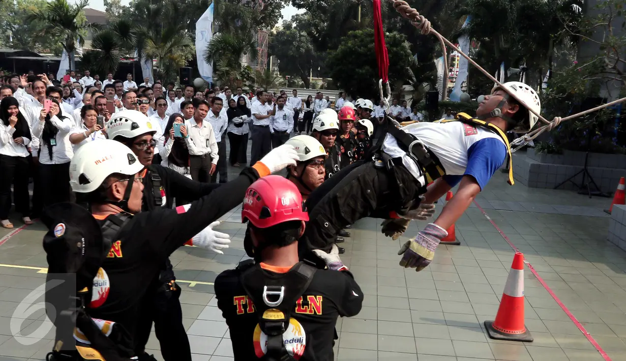 Aksi Tim Reaksi Cepat Penanggulangan Bencana PLN yang melakukan simulasi penyelamatan korban bencana dari lantai 17 dan lantai 5 Kantor Pusat PLN usai upacara peringatan Hari Listrik Nasional ke-70, Jakarta, Selasa (27/10). (Liputan6.com/Angga Yuniar)