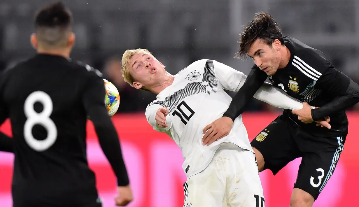 Bintang muda timnas Jerman, Julian Brandt, melompat saat berebut bola dengan pemain Timnas Argentina Nicolas Tagliafico dalam laga persahabatan di Stadion Signal Iduna Park, Dortmund, Rabu (9/10/2019).  Menghadapi Argentina, Timnas Jerman harus puas bermain 2-2 dengan lawannya. (AP/Martin Meissner)
