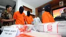 Petugas Ditpidsiber Mabes Polri menggiring tiga tersangka jaringan jual beli surat keterangan sakit online usai rilis di Jakarta, Jumat (12/1). Ditpidsiber Mabes Polri menangkap tiga tersangka berikut barang bukti. (Liputan6.com/Helmi Fithriansyah)