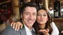 Penyerang Bayern Munchen, Robert Lewandowski bersama istrinya, Anna berpose saat menghadiri festival bir Oktoberfest 2017 di Munich, Jerman (23/9). (AFP Photo/Pool/Alexandra Beier)