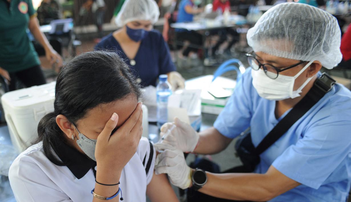 Seorang remaja bereaksi saat menerima vaksin virus corona COVID-19 AstraZeneca di klinik vaksinasi massal darurat di Denpasar, Bali, Selasa (6/7/2021). Indonesia tengah memerangi gelombang infeksi baru yang belum pernah terjadi sebelumnya. (SONNY TUMBELAKA