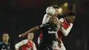 Pemain West Ham United, Andre Ayew (berusaha menyundul bola dari kepungan pemain Arsenal pada laga Piala Liga Inggris di Emirates Stadium, London, (19/12/2017). Arsenal menang 1-0. (AP/Alastair Grant)