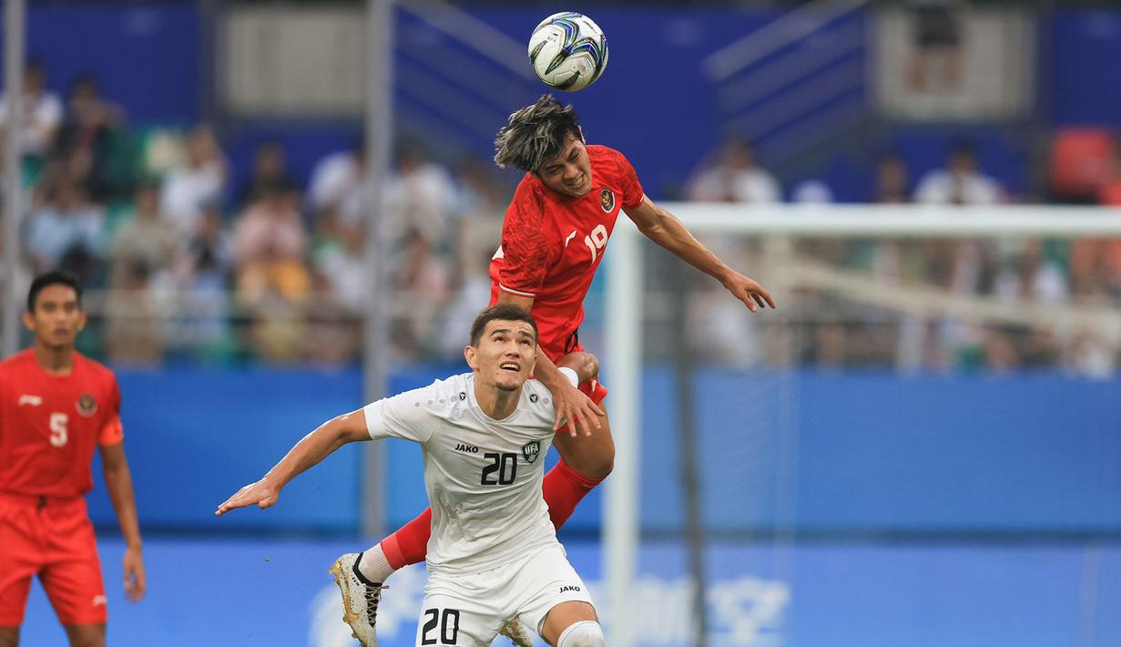 Pemain Timnas Indonesia U-24, Alfeandra Dewangga (tengah atas), berhasil merebut bola di udara saat duel dengan pemain Timnas Uzbekistan U-24, Ruslan Jiyanov dalam pertandingan 16 besar Asian Games 2022 yang berlangsung di Stadion Shangcheng Sports Centre, Kamis (28/9/2023). (Bola.com/NOC/Naif Al'as)